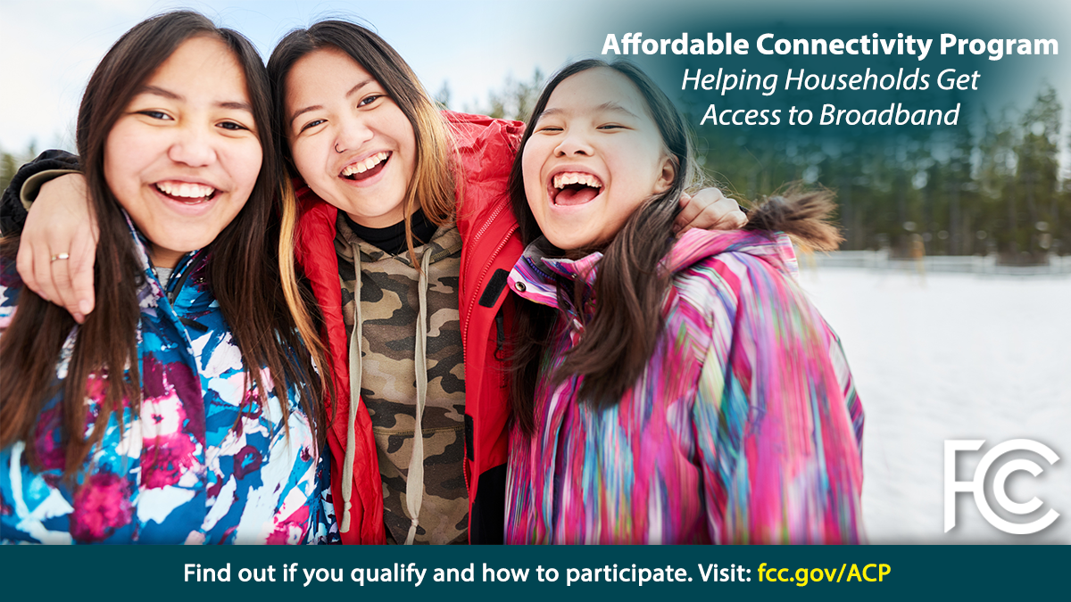 Affordable Connectivity Program. Three young women, arm in arm, wearing coats outside