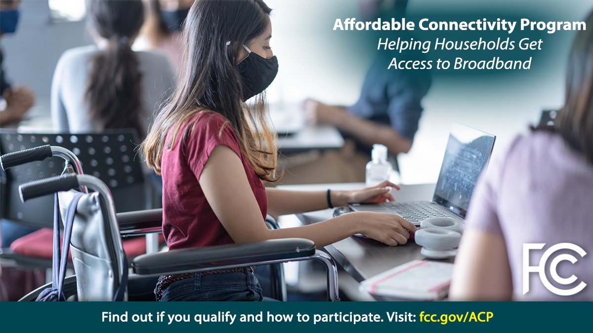Affordable Connectivity Program. Woman wearing cloth medical mask in wheelchair in front of laptop computer on table