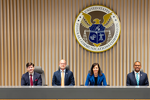 Commissioners group photo in commission meeting room at FCC's Washington DC headquarters, April 21, 2022, L to R: Commissioner Nathan Simington, Commissioner Brendan Carr, Chairwoman Jessica Rosenworcel, and Commissioner Geoffrey Starks