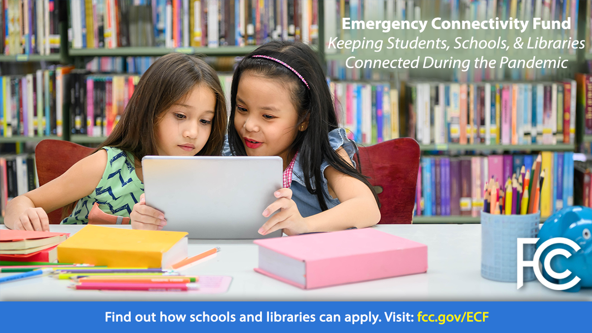Emergency Connectivity Fund - two girls at table in library looking at a tablet computer