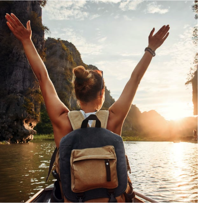 Lady with hands up on a river appearing to be on vacation
