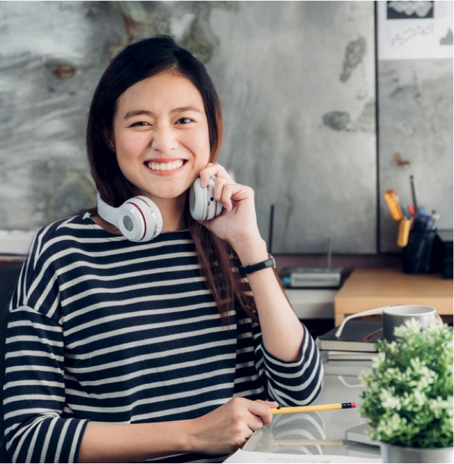 Lady holding head phones smiling because of alternate work schedule